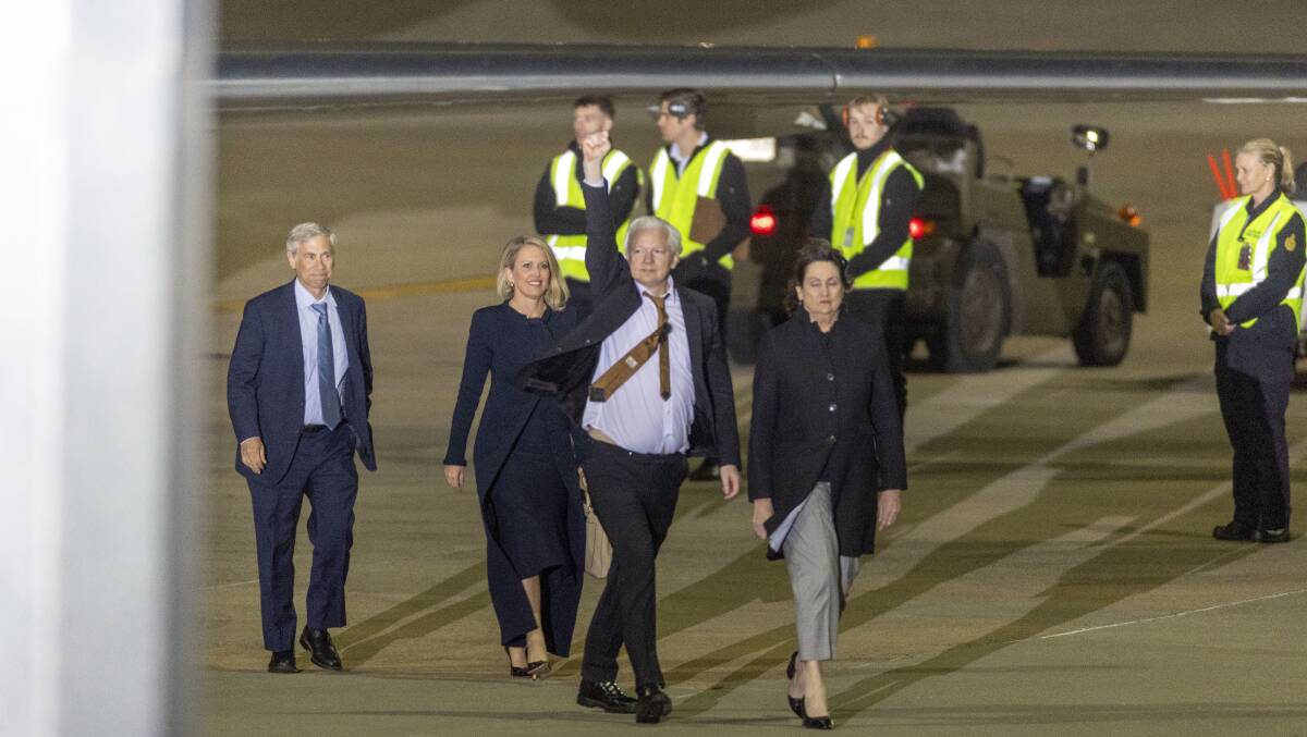 Julian Assange with his legal team on the tarmac after landing in Canberra on Wednesday night. Picture by Gary Ramage